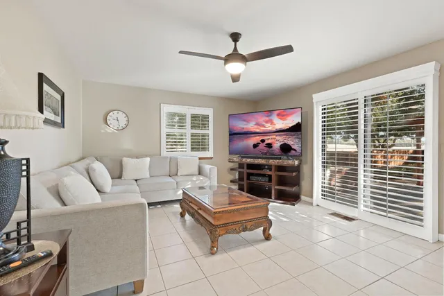 a living room with furniture a flat screen tv and a window