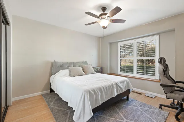 a bedroom with a bed a chair and a large window