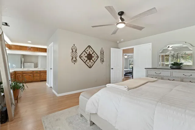 a spacious bedroom with a large bed a chandelier and closet