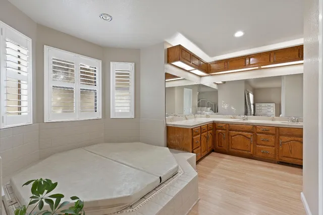 a spacious bathroom with a granite countertop sink and a bathtub