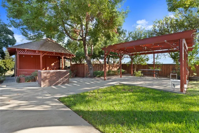 a view of a house with backyard and sitting area