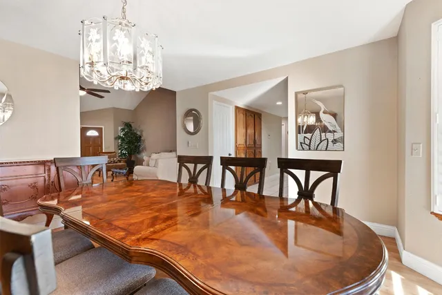 a dining room with furniture a chandelier and kitchen view