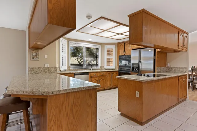 a kitchen with stainless steel appliances granite countertop a sink and a stove