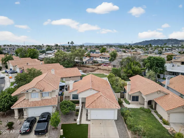 an aerial view of residential houses with outdoor space and trees