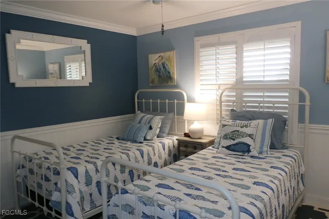 a bedroom with two beds and a chandelier