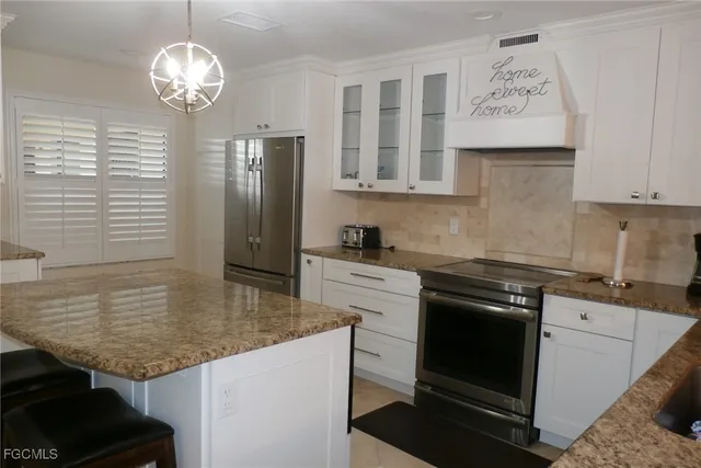 a kitchen with stainless steel appliances granite countertop a sink a stove and refrigerator