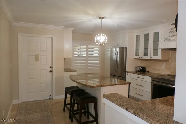 a kitchen with stainless steel appliances granite countertop a sink and a refrigerator