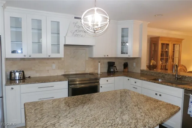a kitchen with granite countertop a sink and a stove