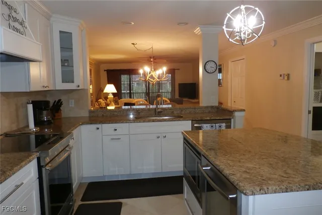 a kitchen with granite countertop stainless steel appliances a stove sink and cabinets