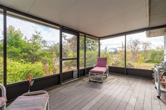 a living room with large windows and wooden floor
