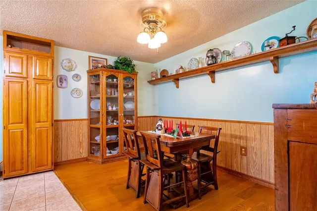 a dining room with furniture and a chandelier fan