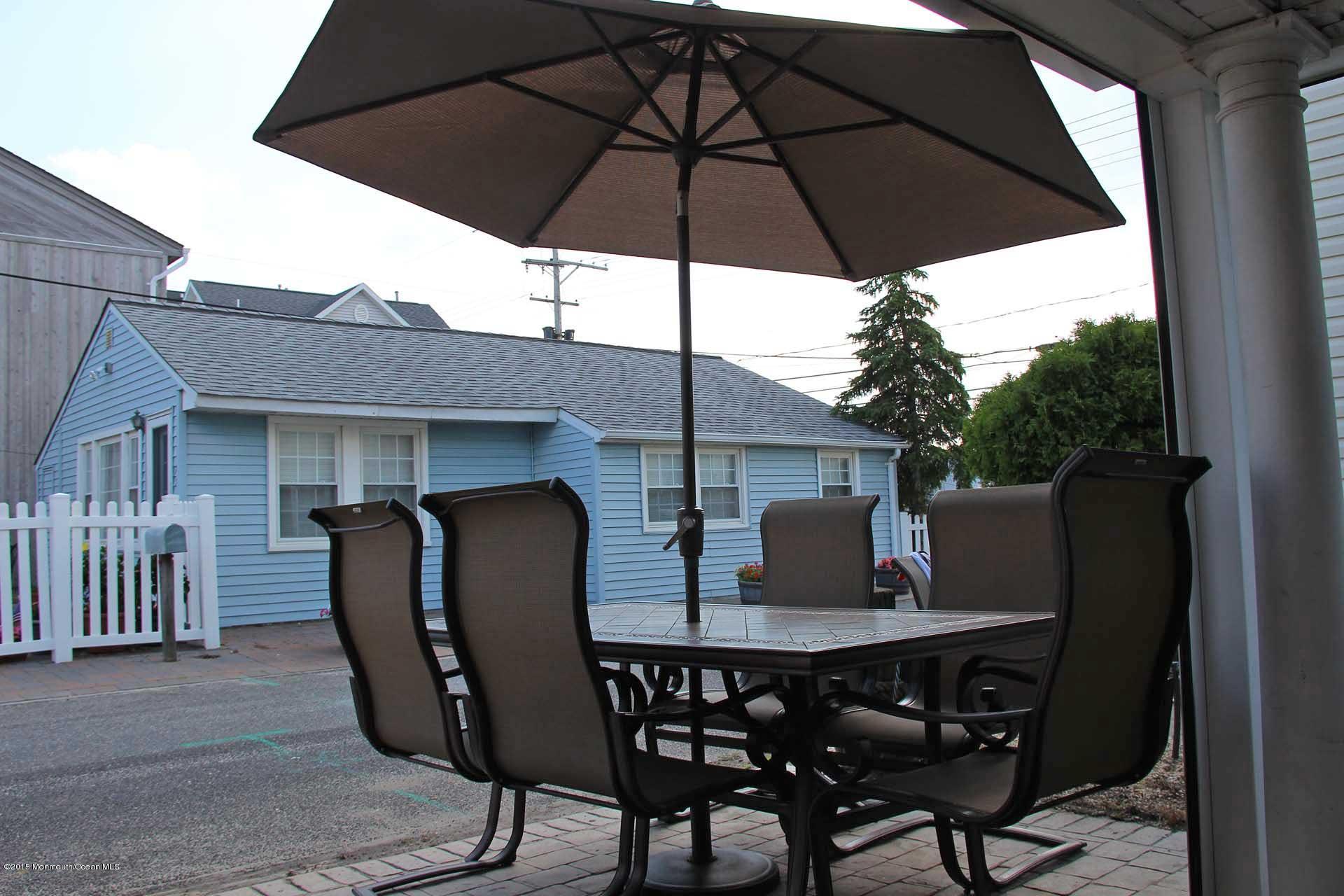 a view of wooden table and chairs under an umbrella