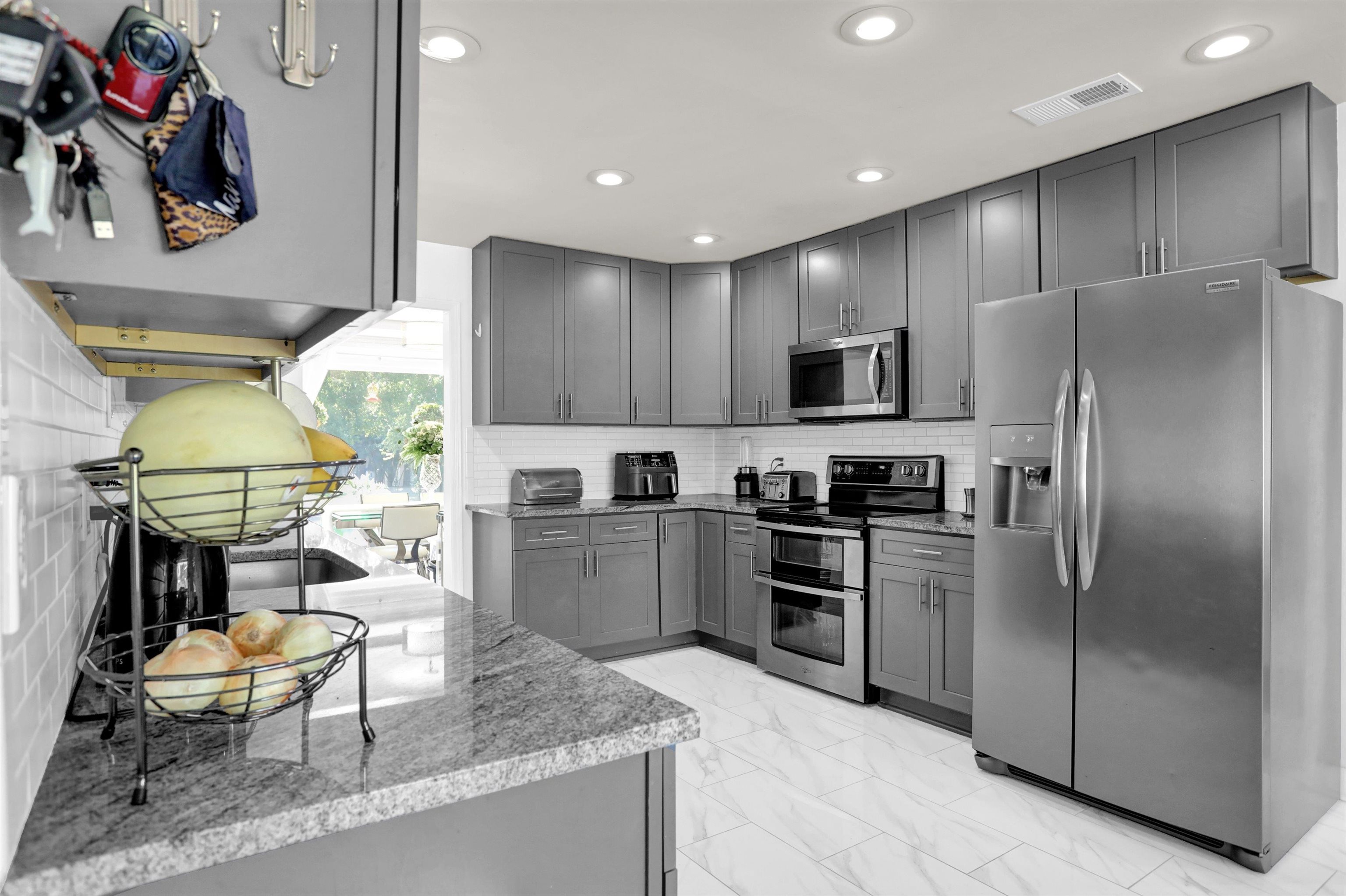 4045 Bartlett Country Road Bartlett, TN 38135 - Photo 13 of 40 a kitchen with stainless steel appliances granite countertop a refrigerator a stove a sink a dining table and chairs