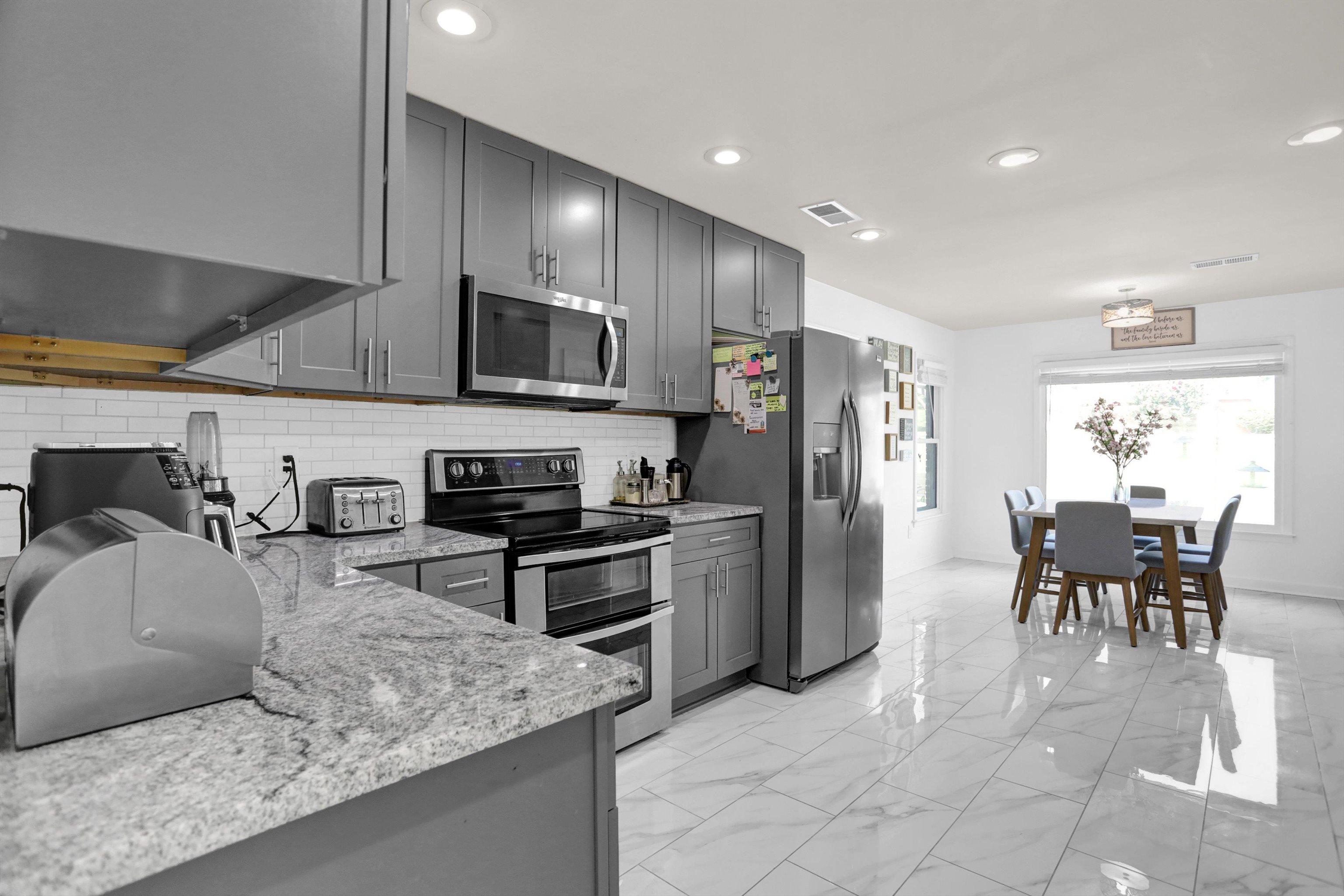 4045 Bartlett Country Road Bartlett, TN 38135 - Photo 16 of 40 a kitchen with stainless steel appliances granite countertop a stove top oven a sink a dining table and chairs