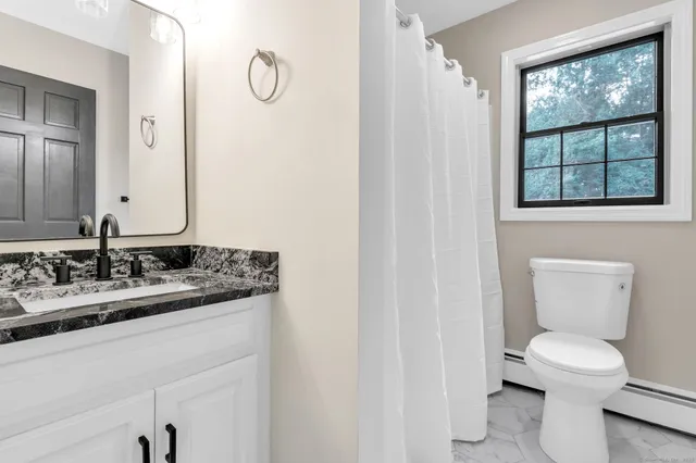 a bathroom with a toilet sink and mirror