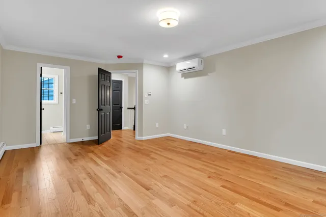 a view of an empty room with wooden floor