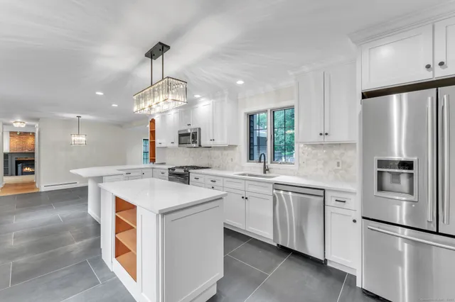 a kitchen with white cabinets and stainless steel appliances