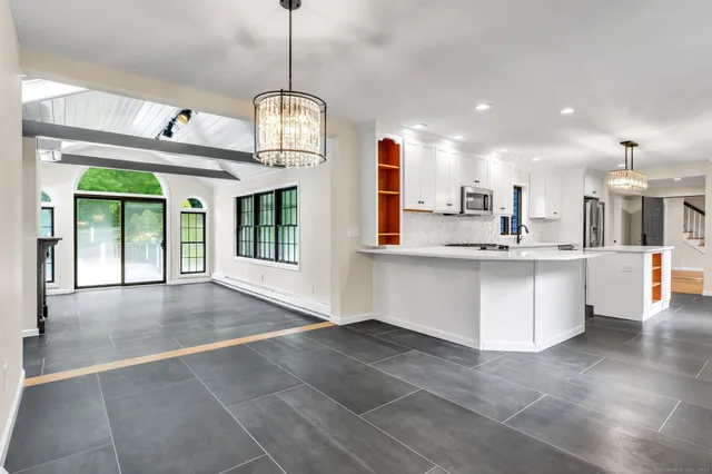 a view of large kitchen with a sink stainless steel appliances and cabinets