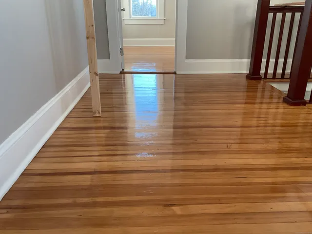 a view of a hallway with wooden floor and staircase