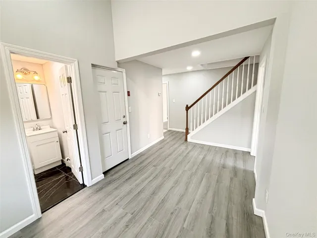 a view of staircase with wooden floor and white walls
