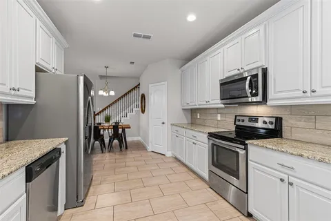 a kitchen with refrigerator and cabinets