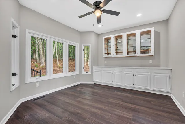 a view of a white house with large windows and a small yard