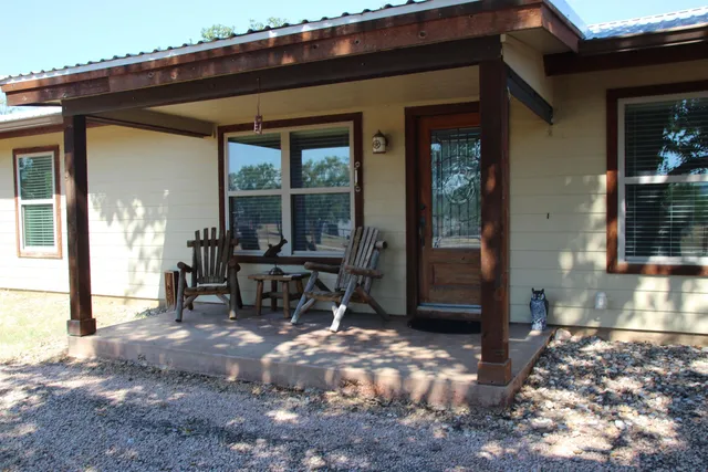 a view of a patio with table and chairs and floor to ceiling window