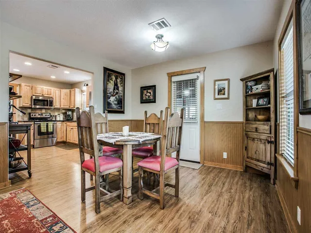a living room with furniture a rug and kitchen view