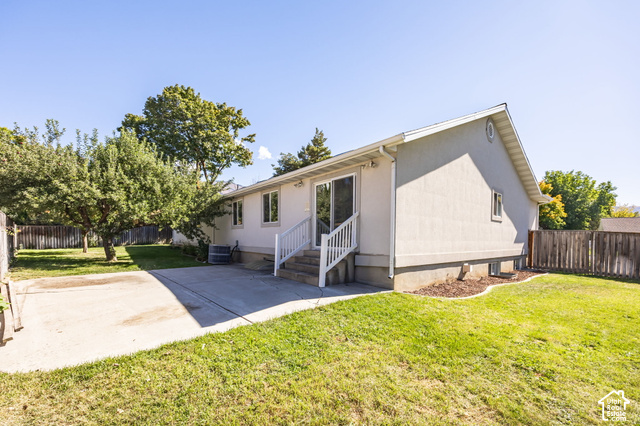 1143 East Mountain Road Logan, UT 84321 - Photo 44 of 64 Exterior featuring a stucco finish, sliding glass door, patio, and a fenced yard with mature trees