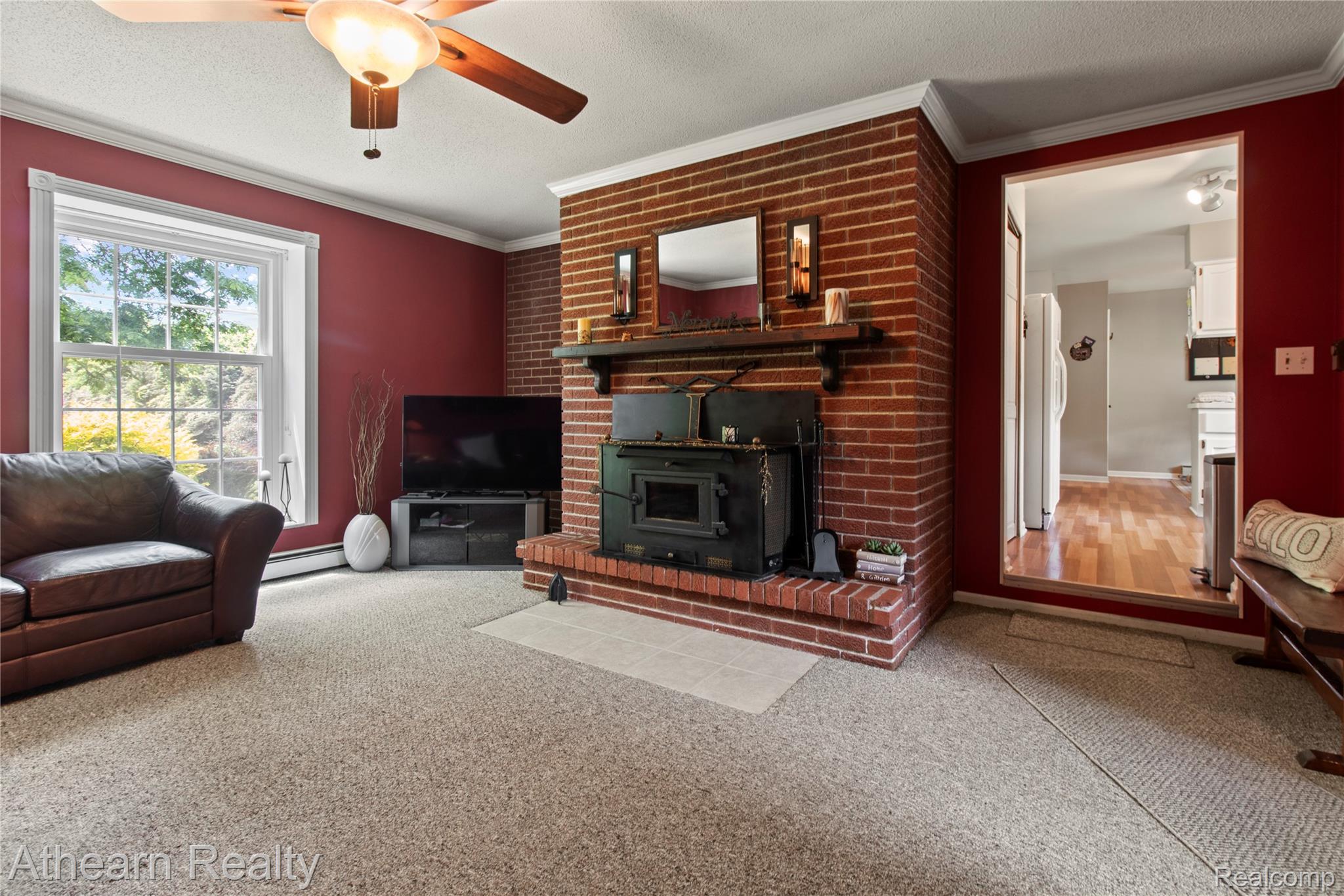 12427 Foley Road Fenton, MI 48430 - Photo 35 of 47 Brick fireplace with a black wood-burning stove, mantel, and hearth