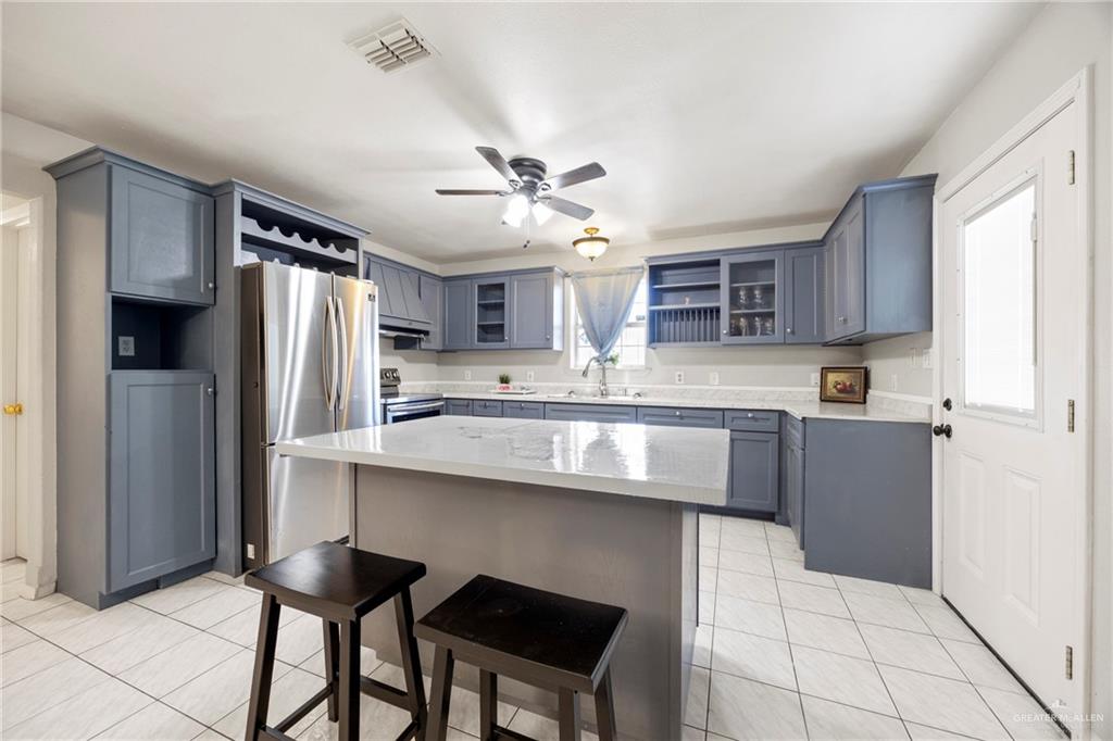 1124 Orange Street Mercedes, TX 78570 - Photo 5 of 17 a kitchen with stainless steel appliances granite countertop a refrigerator and a stove top oven