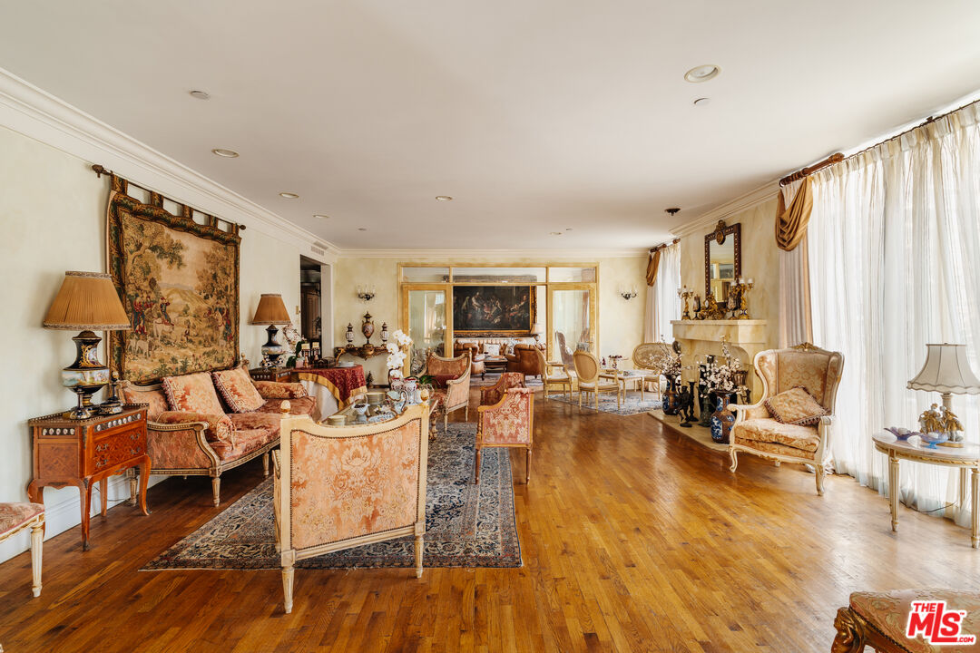 a living room with fireplace furniture and a large window