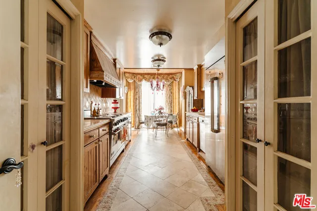 a hallway with a large window and kitchen view