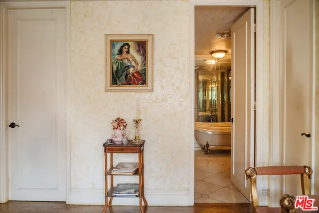 a view of a hallway with wooden floor and a bathroom