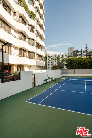 a view of swimming pool with seating area and trees in the background