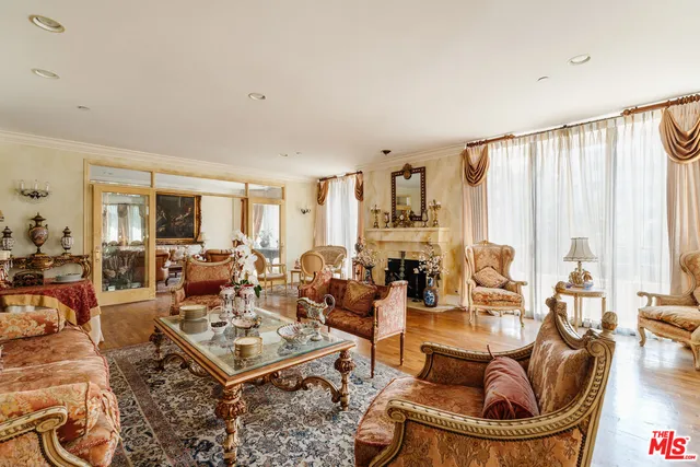 a living room with fireplace furniture and a large window