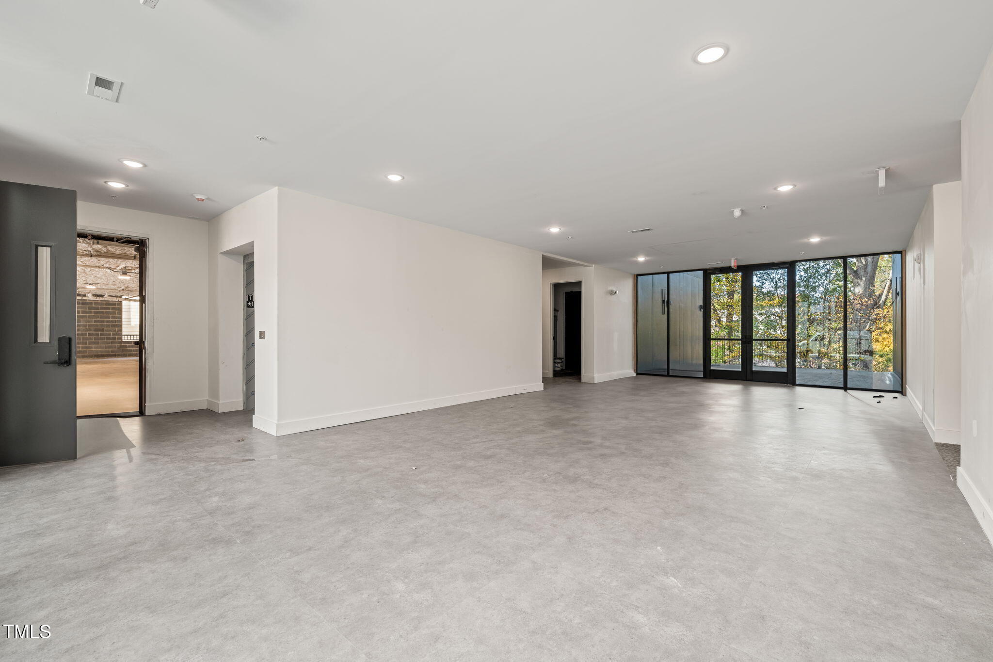 29 Enterprise Street, Unit 201 Raleigh, NC 27607 - Photo 12 of 33 a view of an empty room with glass door