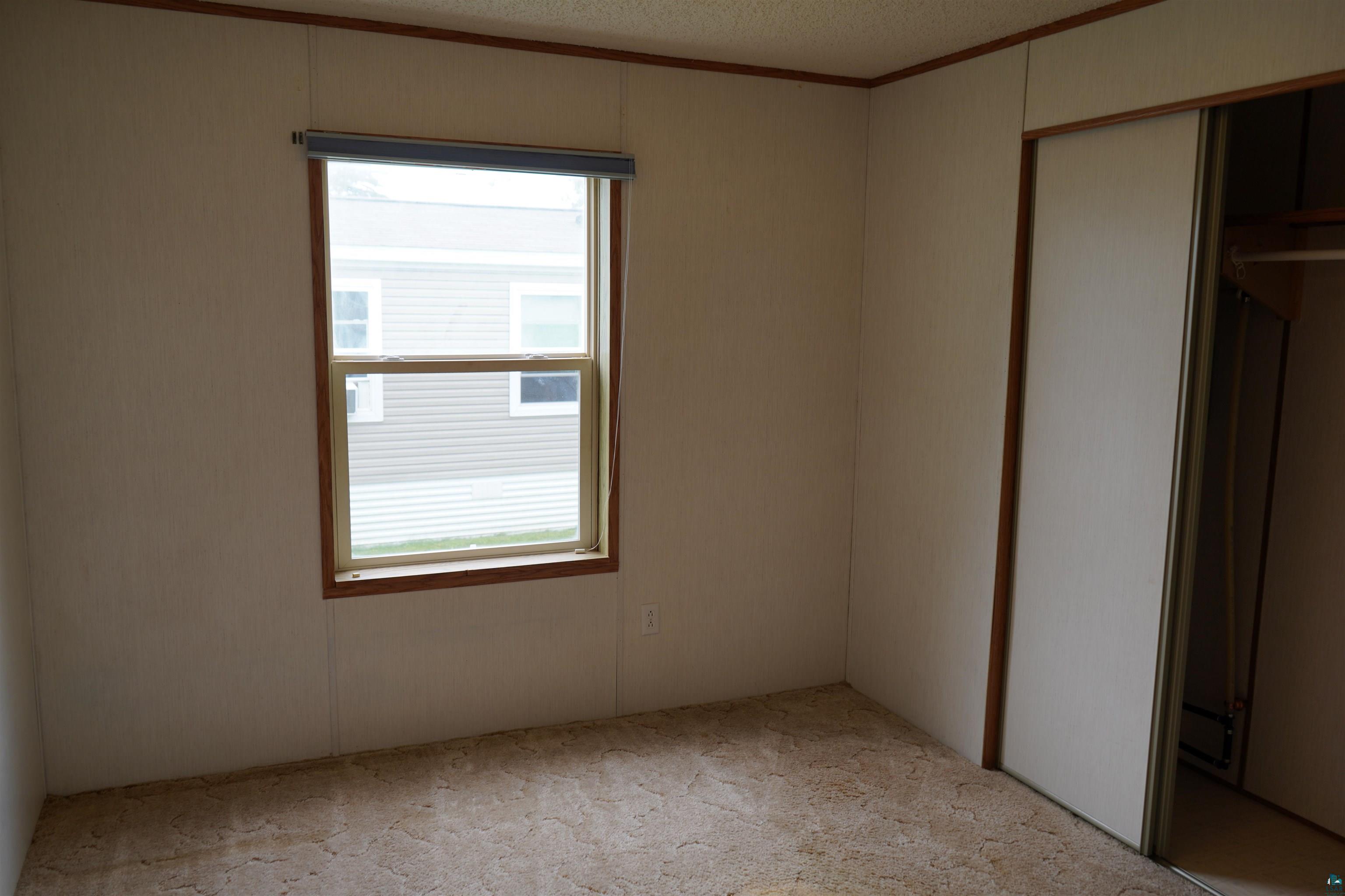 47 Coban Drive Duluth, MN 55808 - Photo 19 of 23 Unfurnished bedroom with carpet floors, crown molding, a closet, and a textured ceiling