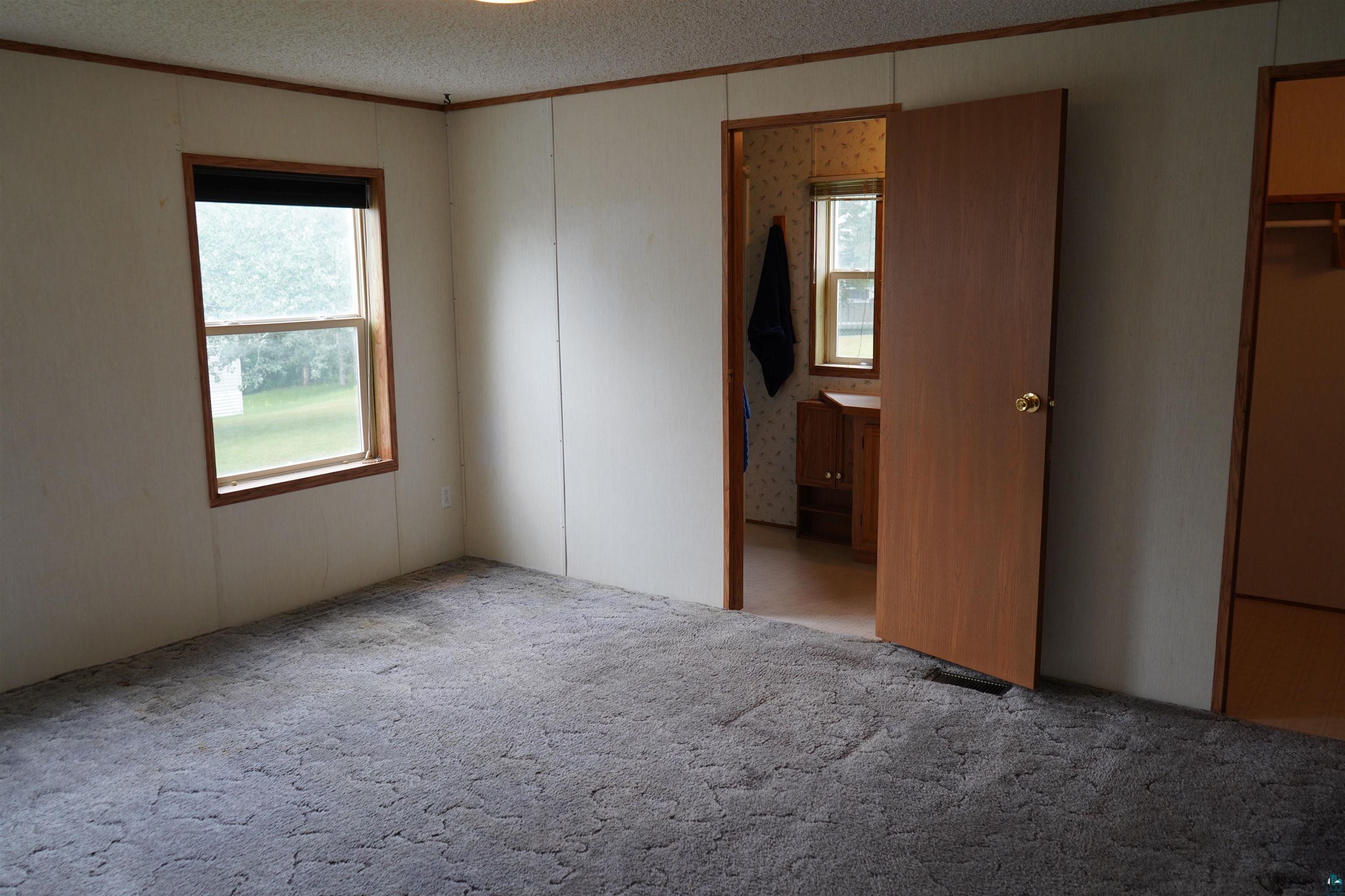 47 Coban Drive Duluth, MN 55808 - Photo 22 of 23 Unfurnished bedroom featuring crown molding, carpet, and a textured ceiling