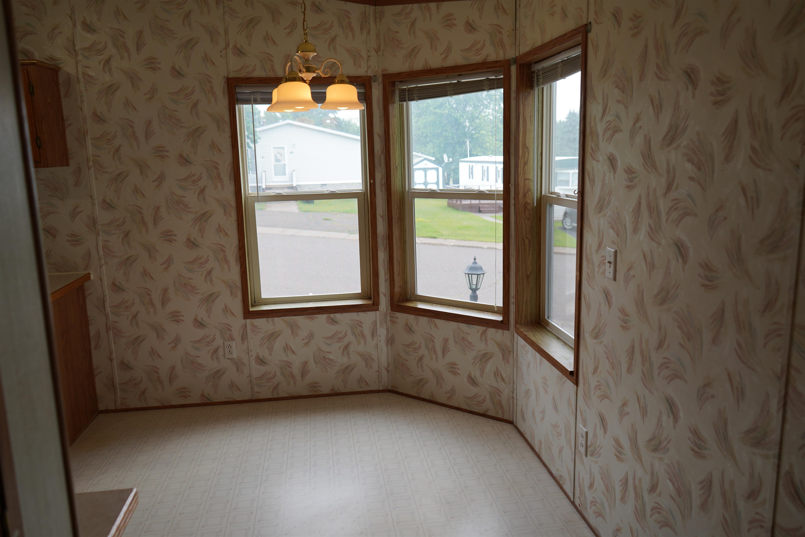 47 Coban Drive Duluth, MN 55808 - Photo 10 of 23 Unfurnished dining area with wallpapered walls, a chandelier, and light floors