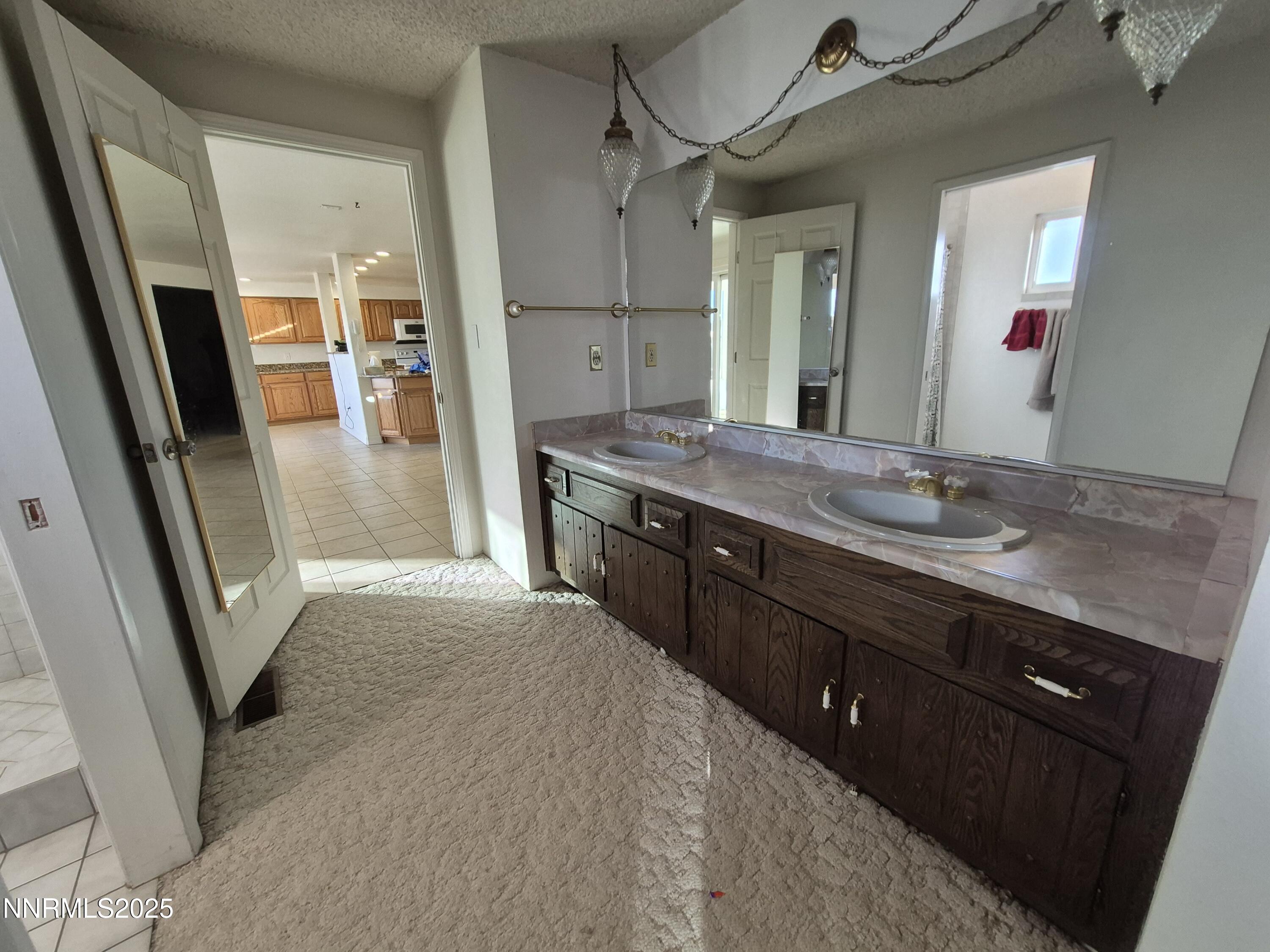 7215 Marlin Drive Reno, NV 89506 - Photo 16 of 40 a spacious bathroom with a granite countertop sink a mirror and a shower