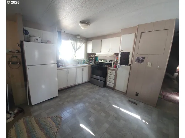 a kitchen with refrigerator and cabinets
