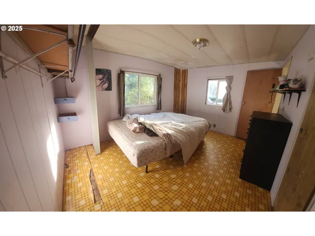 a living room with a bed furniture and a window