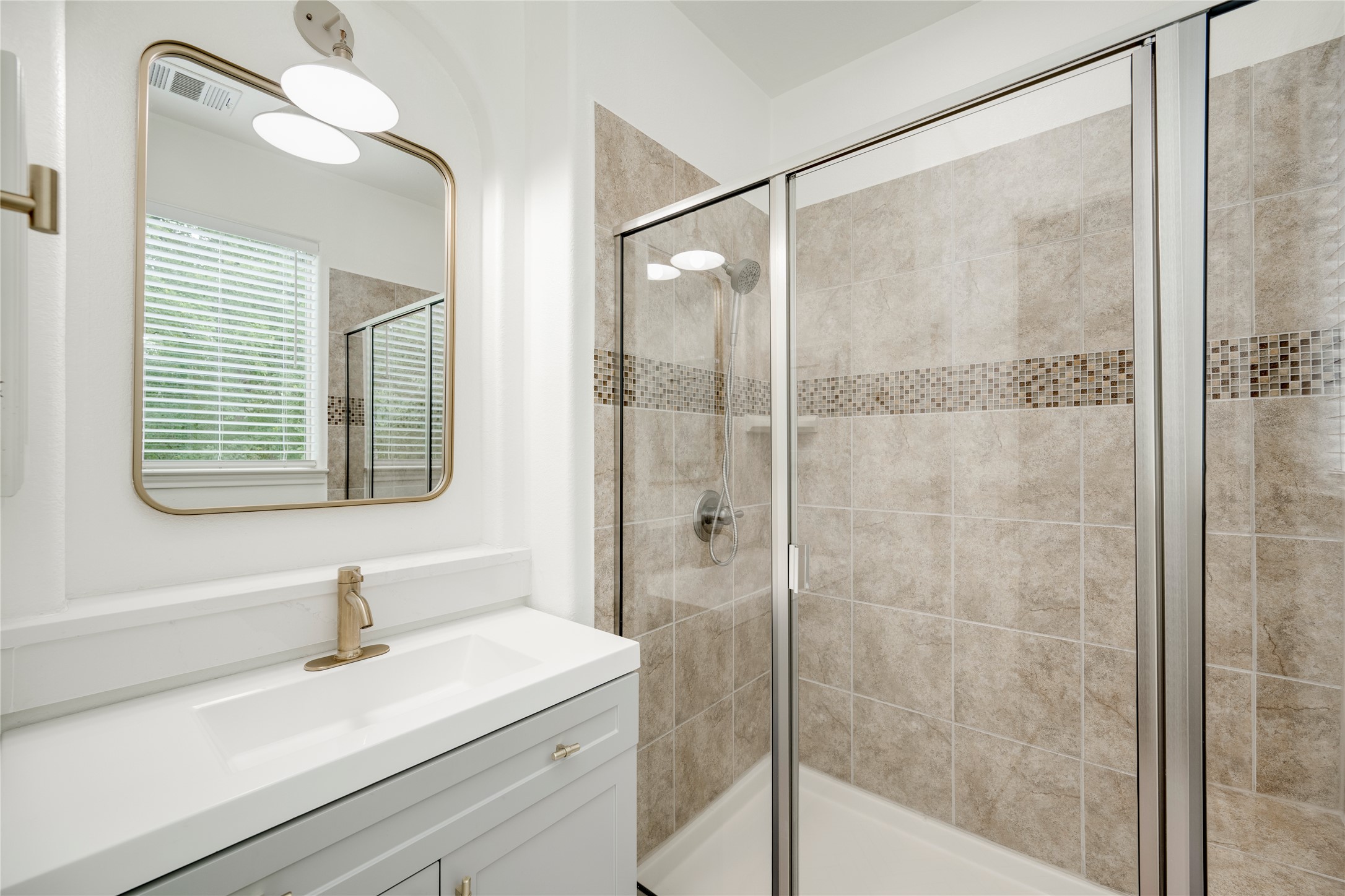 6008 Whipple Way Austin, TX 78745 - Photo 25 of 39 A refined bathroom featuring a contemporary vanity, framed mirror, and a sleek tiled shower.