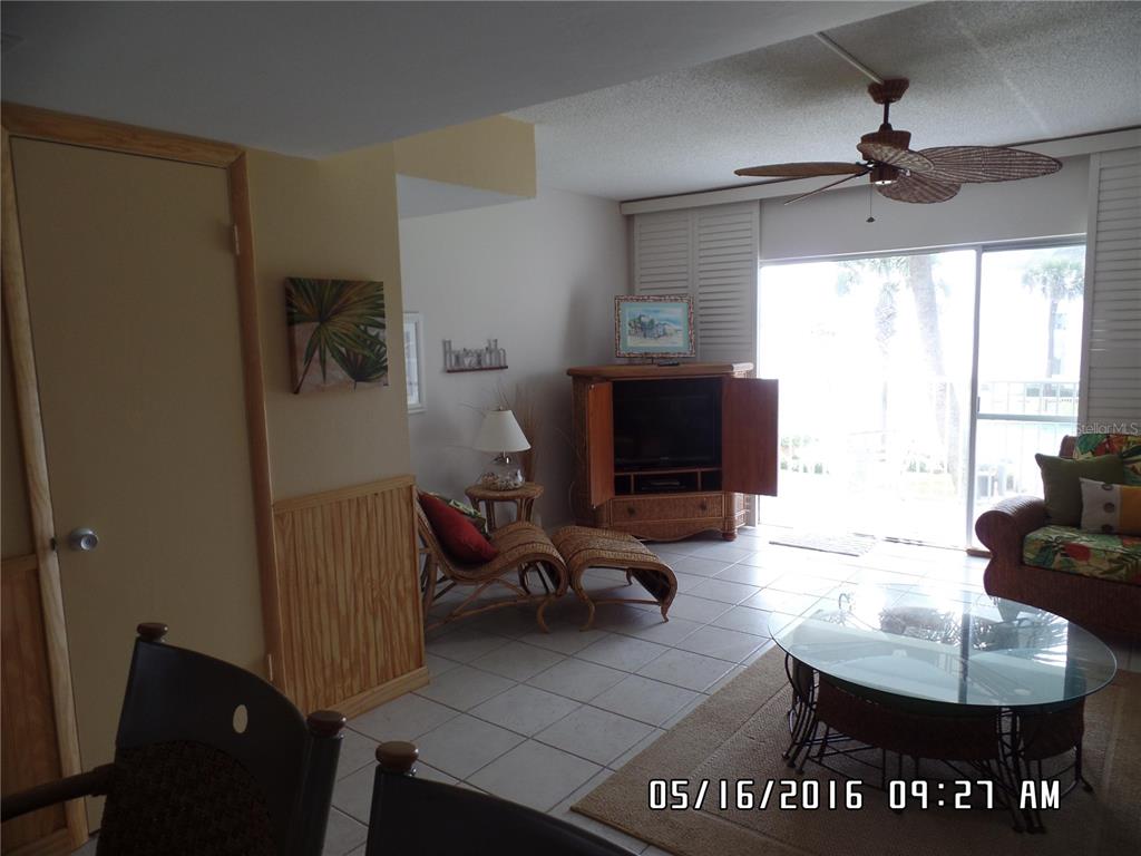 815 Ocean Shore Boulevard, Unit 9A Ormond Beach, FL 32176 - Photo 5 of 9 a living room with furniture and a flat screen tv