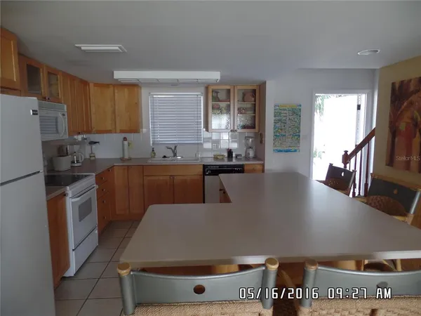 a living room with stainless steel appliances furniture a refrigerator a sink a stove a microwave and cabinets