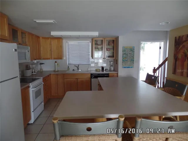 a living room with stainless steel appliances furniture a refrigerator a sink a stove a microwave and cabinets