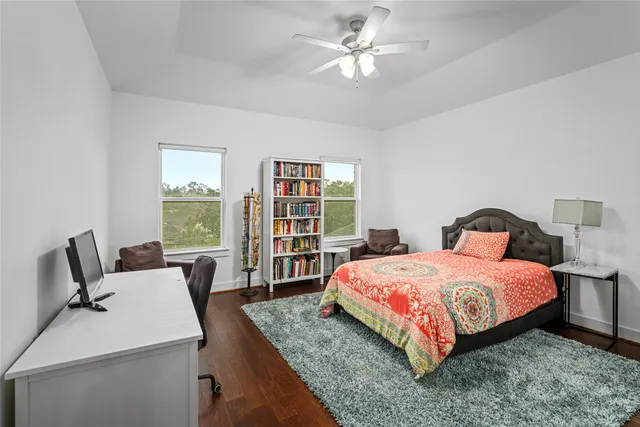 a bedroom with a bed a couch and large window