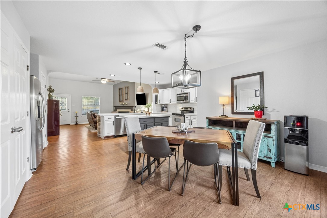 1328 Cottonwood Road Fischer, TX 78623 - Photo 14 of 35 a view of a dining room and livingroom with furniture wooden floor a rug a chandelier