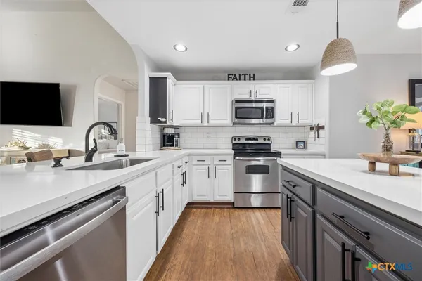 a kitchen with a sink stove and microwave